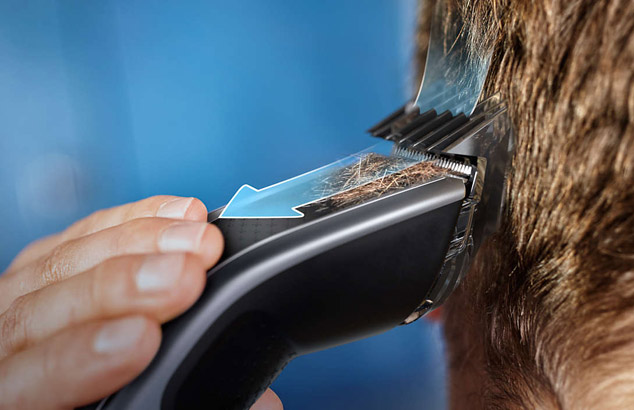 Ein Mann benutzt eine Philips Haarschneidemaschine. Ein Pfeil zeigt die Richtung an, in der das Haar geschnitten wird.